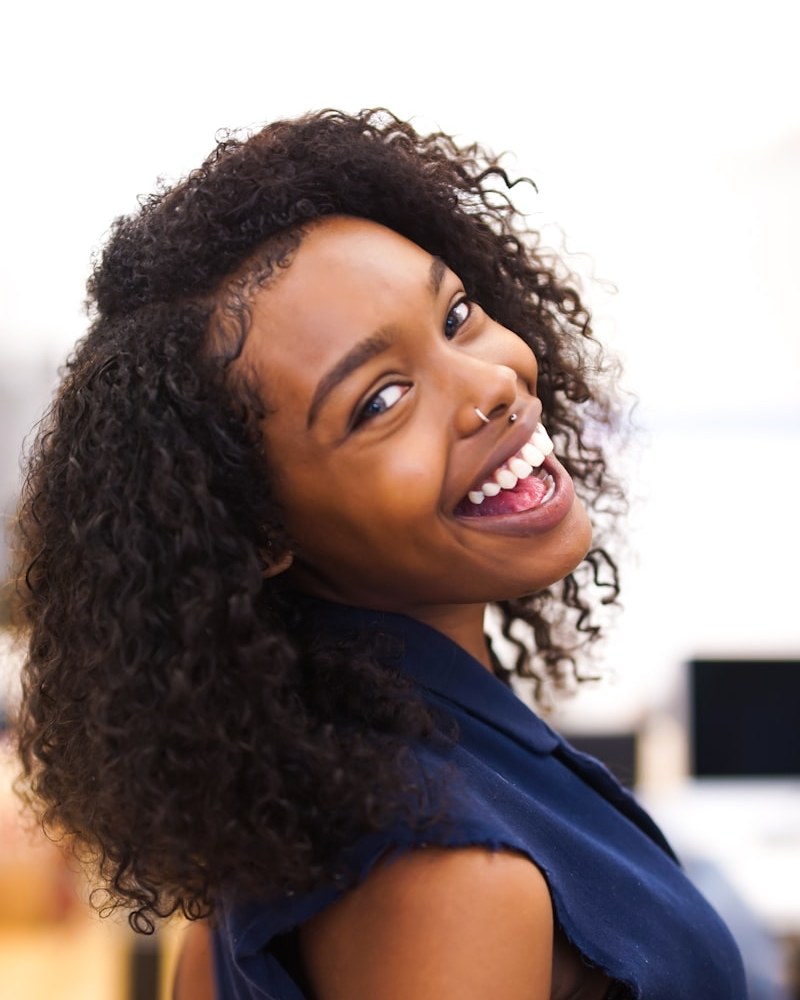 Joyful Black woman with lustrous, flowing loose wavy natural hair